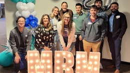 Photo of students in front of a sign that says MRM lit up