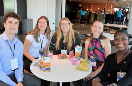 Attendees smiling while sitting at a table together
