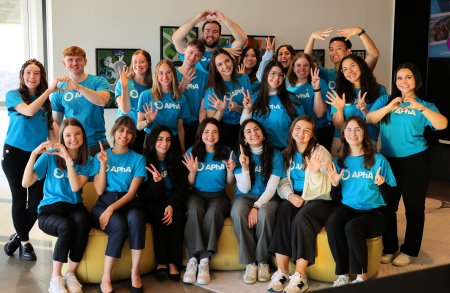 Group of attendees smiling and waving for the camera